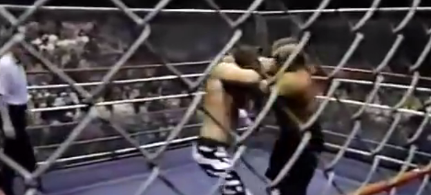 Jimmy Garvin locks up with Animal within the steel cage